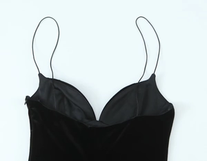 Detail of black velvet bodysuit with thin straps and a clean V-neckline cut