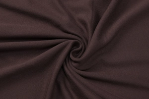 Close-up of soft dark brown knit fabric texture with elegant spiral pleated details