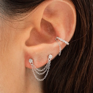 Detail of 925 silver double chain earrings and zircon ear cuff worn by a model