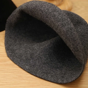 Close-up of thick dark grey wool felt texture on a foldable winter bucket hat for women