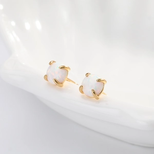 Close-up of gold-plated S925 silver stud earrings featuring round white opal stones