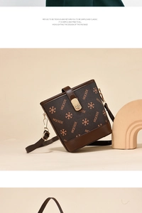 Detail of a brown bucket bag with orange star-letter prints and a metal buckle closure