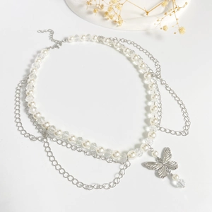 Detail of silver butterfly pendant with white pearl and metallic layered fringe necklace