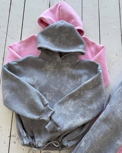 Détail de sweats à capuche délavés en gris et rose avec coupe oversize et poignets côtelés