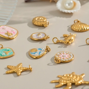 Golden sea animal and floral pendants with pearls and rhinestones on a beige surface