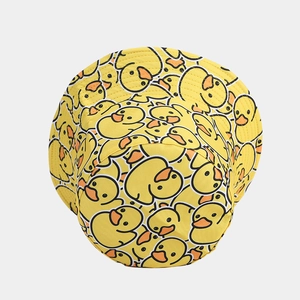 Detailed close-up of yellow reversible bucket hat with cute cartoon duck patterns