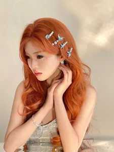 Close-up of ocean-themed mermaid tail and shell hairpins with pearls on wavy hair