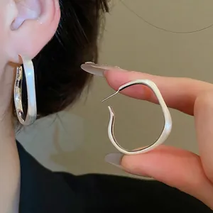 Irregular matte silver hoop earrings with a minimalist geometric design for women