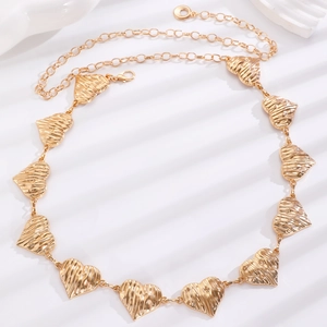 Detailed view of gold metal heart-shaped chain belt with textured vertical pattern and clasp