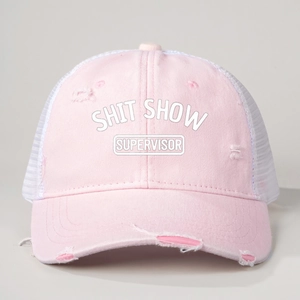 Detailed macro view of distressed pink trucker hat with Shit Show Supervisor text