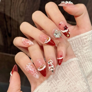 Detail of red velvet Christmas press-on nails with 3D snowflake and tree accents
