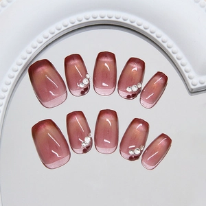 Cat eye press-on nails in rosewood shade with rhinestones on a decorative mirror base