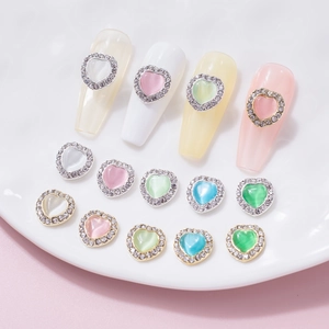 Macro shot of macaron cat eye heart nail art charms with rhinestone frames on nail tips