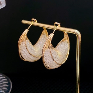 Detailansicht goldener Mesh-Ohrringe mit transparenten Perlen auf einem Display