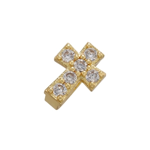 Macro shot of gold cross charm with micro-pave cubic zirconia inlay for DIY jewelry