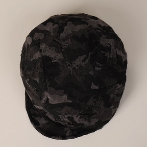 Close-up of distressed camouflage cotton cap with ragged edges and vintage texture