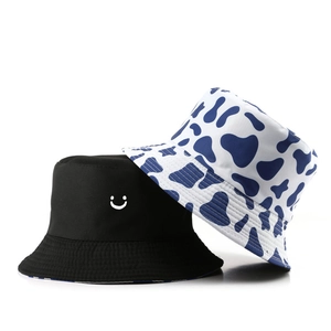 Cappello a secchiello reversibile alla moda con ricamo sorriso e stampa mucca blu