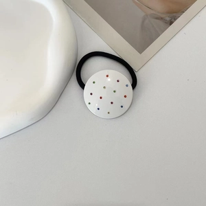 Detail of white round hair scrunchie with colorful rhinestones on a minimalist background