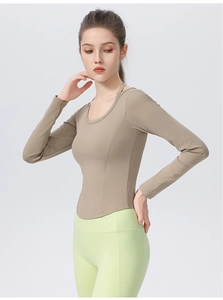 Macro view of tight-fit long sleeve yoga shirt with a curved hem in khaki earth tone