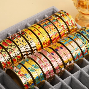 Detail of diverse cloisonne enamel bangles with colorful patterns in a grey jewelry tray
