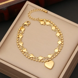 Double layer gold heart necklace with pearls and heart pendant in a beige jewelry box