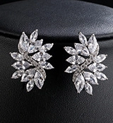 Macro view of marquise-cut zircon leaf earrings with sparkling silver setting and pearls
