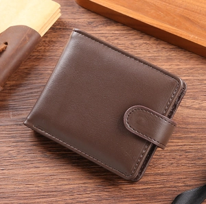 Detailed view of a brown vintage PU leather wallet with snap closure on a wooden desk