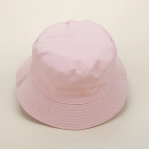 Close-up of pink cotton daisy bucket hat featuring a wide brim and textured canvas fabric