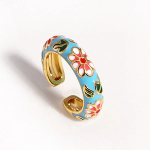 Detailed macro view of light blue enamel floral ring with gold finish and open band