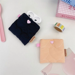 Detail showing two quilted heart pattern headphone pouches with heart-shaped buttons