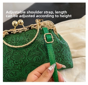 Detail of emerald green embossed shell bag with gold clasp and adjustable strap
