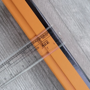 Close-up measuring 4cm width of the textured leather protective edge strip with a ruler