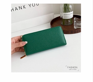Close-up of emerald green long zipper wallet with lychee grain texture and gold hardware