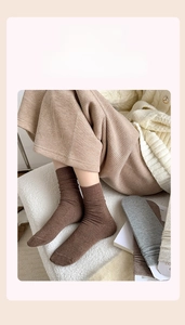 Detail of ribbed knit crew socks in dark brown showing the soft texture and elastic cuff