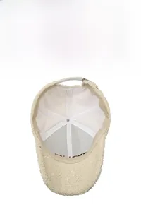 Detail of off-white teddy fleece baseball cap showing reinforced stitching and sweatband