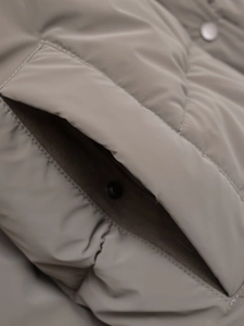 Detail of the side pocket on a matte taupe puffer jacket with refined stitching and snap button