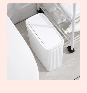 Detailed view of white slim trash can with press-top lid fitting in tight bathroom gap