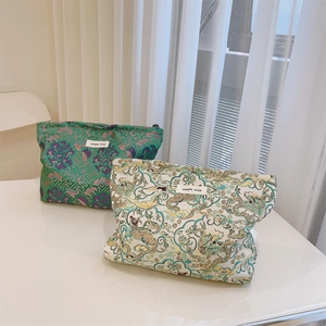 Detail of Chinese jacquard canvas cosmetic bags featuring emerald peony and dragon cloud patterns