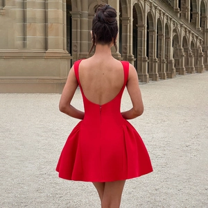Elegantes rotes rückenfreies Minikleid mit Faltenrock in einem europäischen Flur