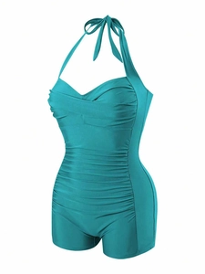 Close-up of ruched stomach area on teal one-piece halter swimsuit for tummy control