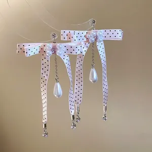 Elegant Korean style bow earrings with pink polka dots and long drop pearls on silver pins