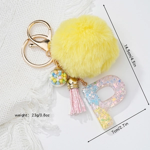 Detail view of resin letter P keychain with yellow pompom and size measurements