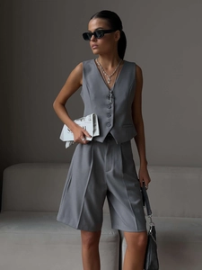 Detail of grey V-neck vest and matching high-waisted shorts with pleated design