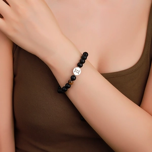 Handmade Gemini zodiac bracelet featuring black matte beads and tiger eye stone