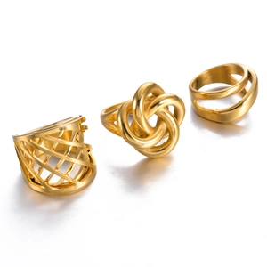 Detailed view of three gold stainless steel rings with knotted and hollow mesh designs