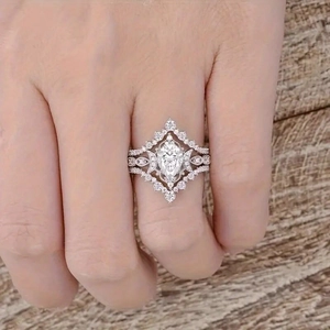 Close-up of bohemian bridal ring set with marquise center stone on a hand