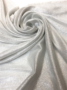Close-up of sparkling silver metallic knit fabric with elegant flowing texture for scarves