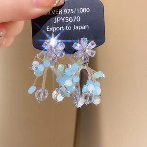 Detailed close-up of 925 silver flower earrings with elegant blue beaded tassels
