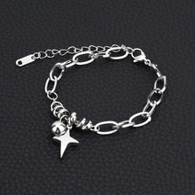 Detailed view of silver thick chain bracelet with star and bead charms on black texture