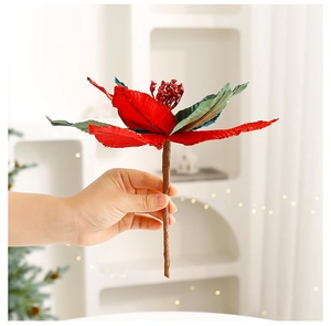 Detail of glittery red poinsettia Christmas tree flower held in hand for scale